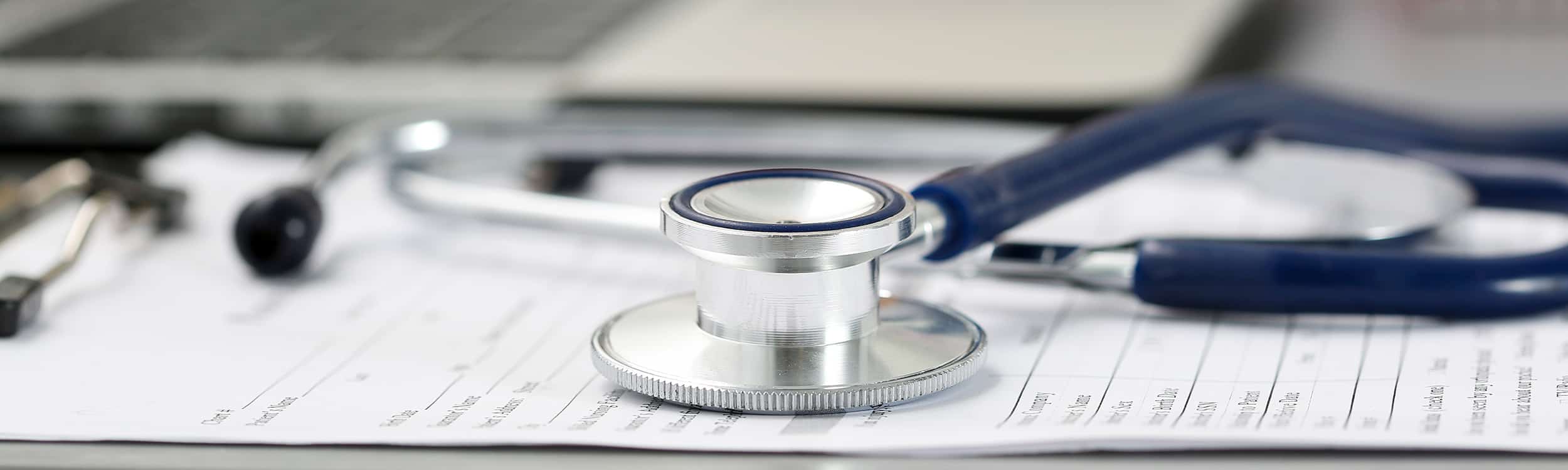 A stethoscope laying on a medical record