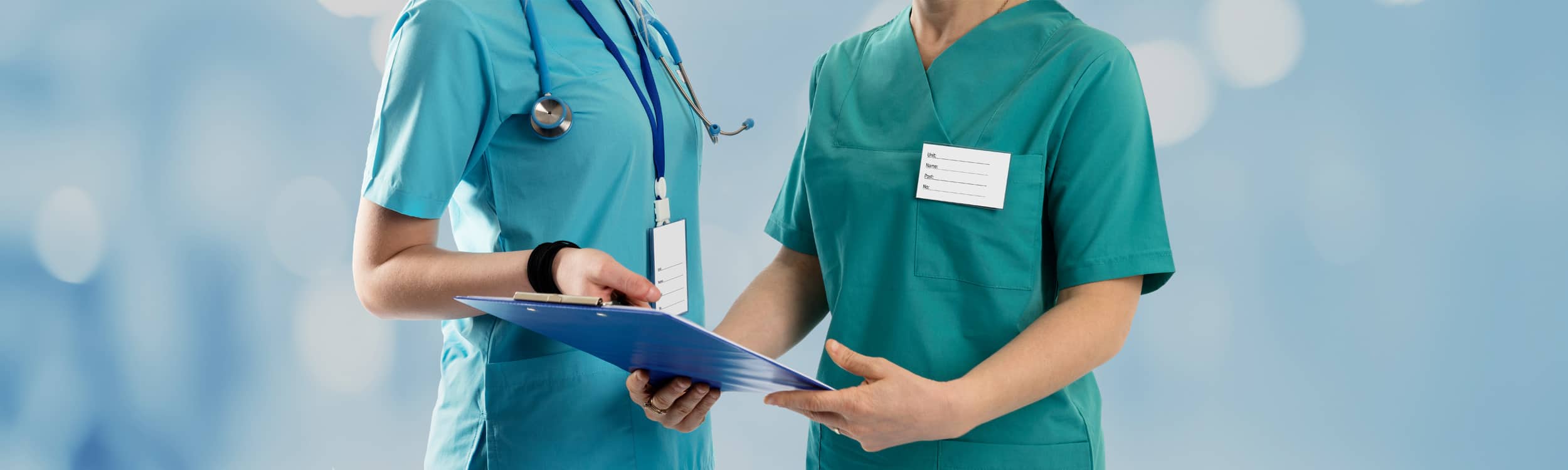 Two providers discuss a document on a clipboard